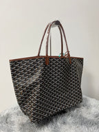 Goyard patterned tote bag with two brown leather handles and open top, dark monogram