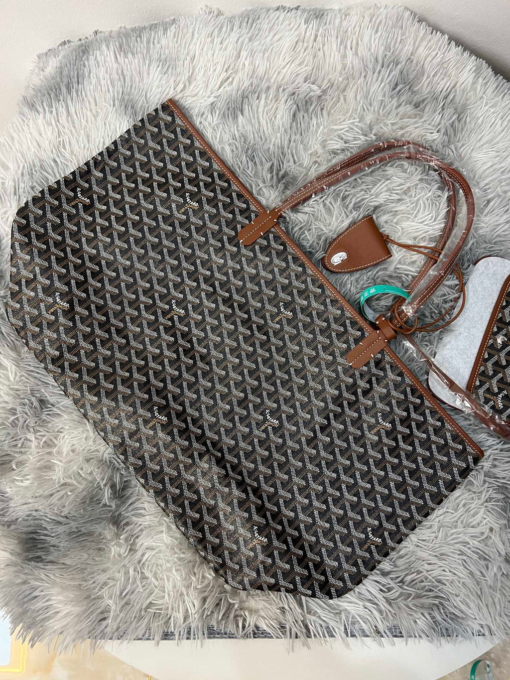 Goyard patterned tote bag with brown leather trim and top handle, dark monogram print