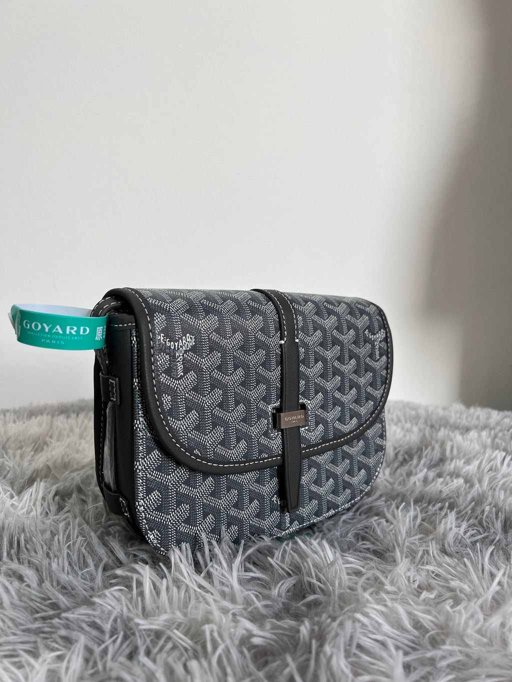 Small crossbody bag with dark monogram pattern, flap closure and black leather strap