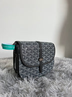 Small crossbody bag with dark monogram pattern, flap closure and black leather strap
