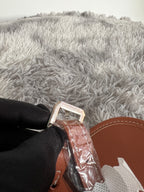 Monogram bag strap end with metal clasp and tan leather edging