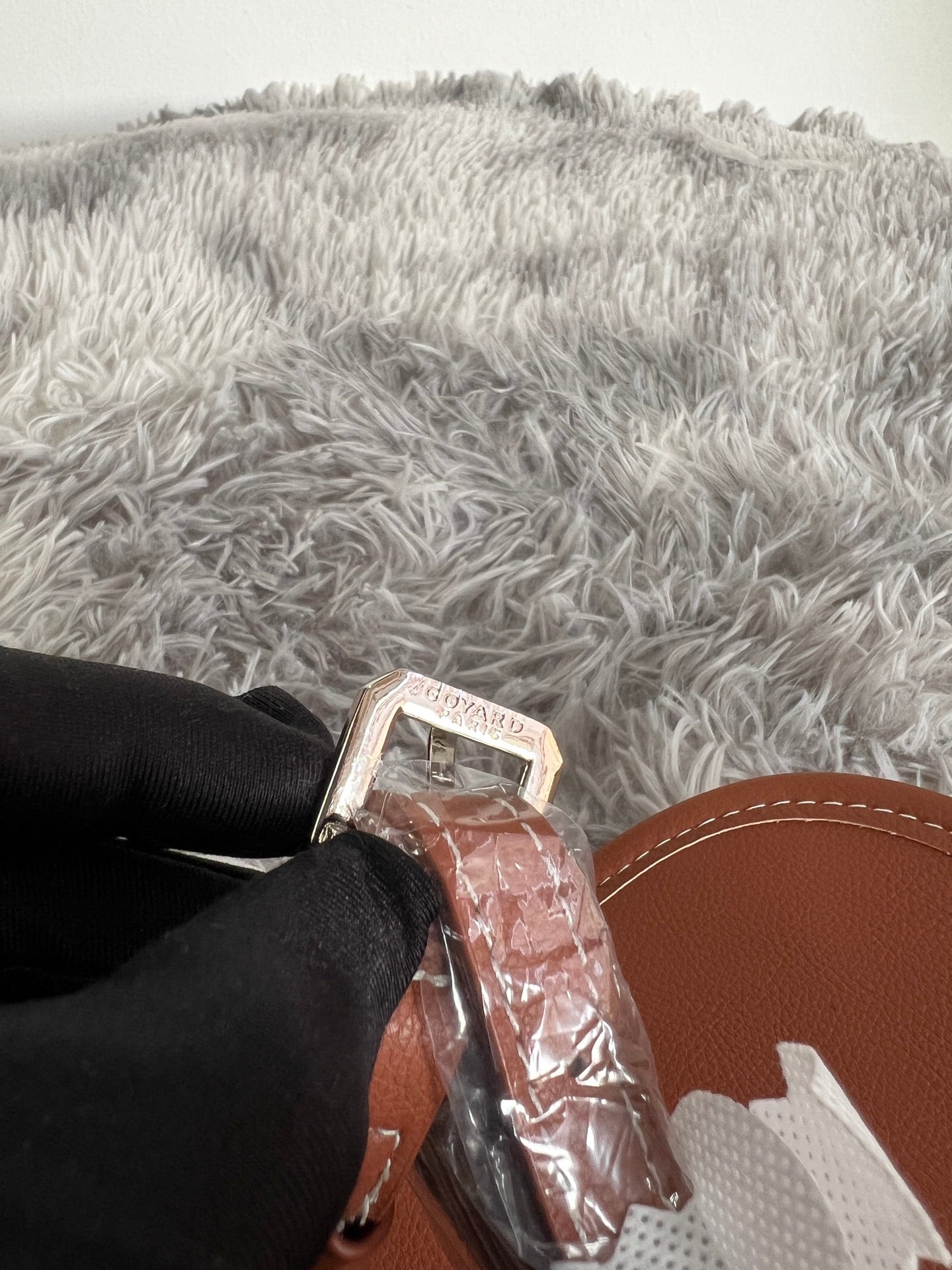 Monogram bag strap end with metal clasp and tan leather edging