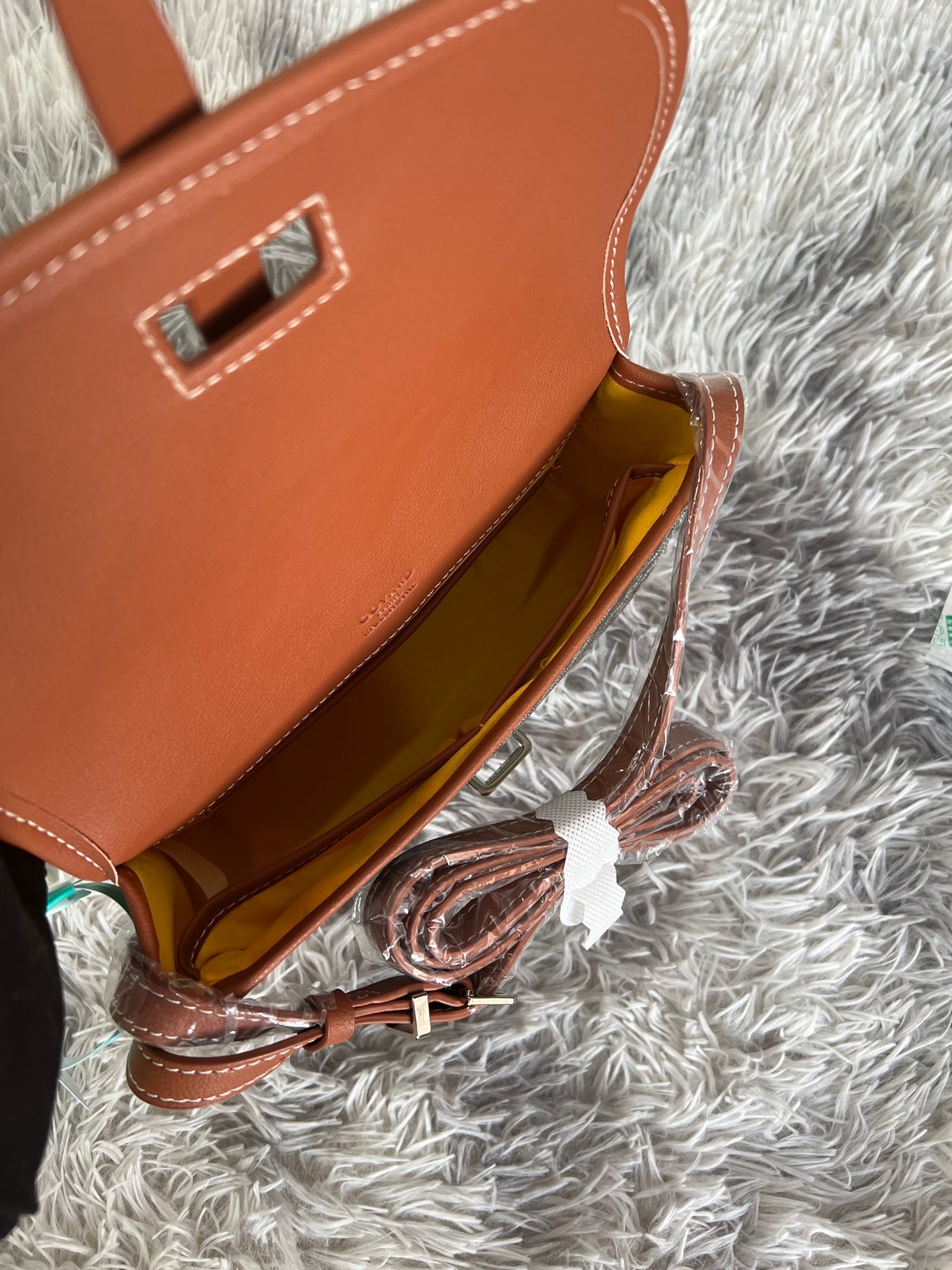 Open monogram crossbody bag with tan leather interior and top strap hardware