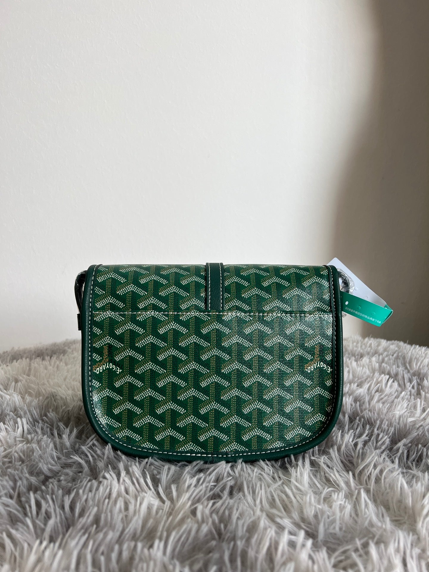 Green patterned Goyard crossbody bag with front flap and adjustable shoulder strap
