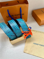 Blue-and-turquoise patterned belt with red LV buckle, shown folded in the box.