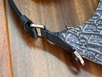 Adjustable strap end with metal hardware on blue Oblique patterned bag