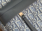 Dior bag detail with textured dark leather panel and stitched monogram fabric trim