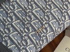Close-up of Dior blue monogram fabric with all-over pattern and gold-tone Dior lettering