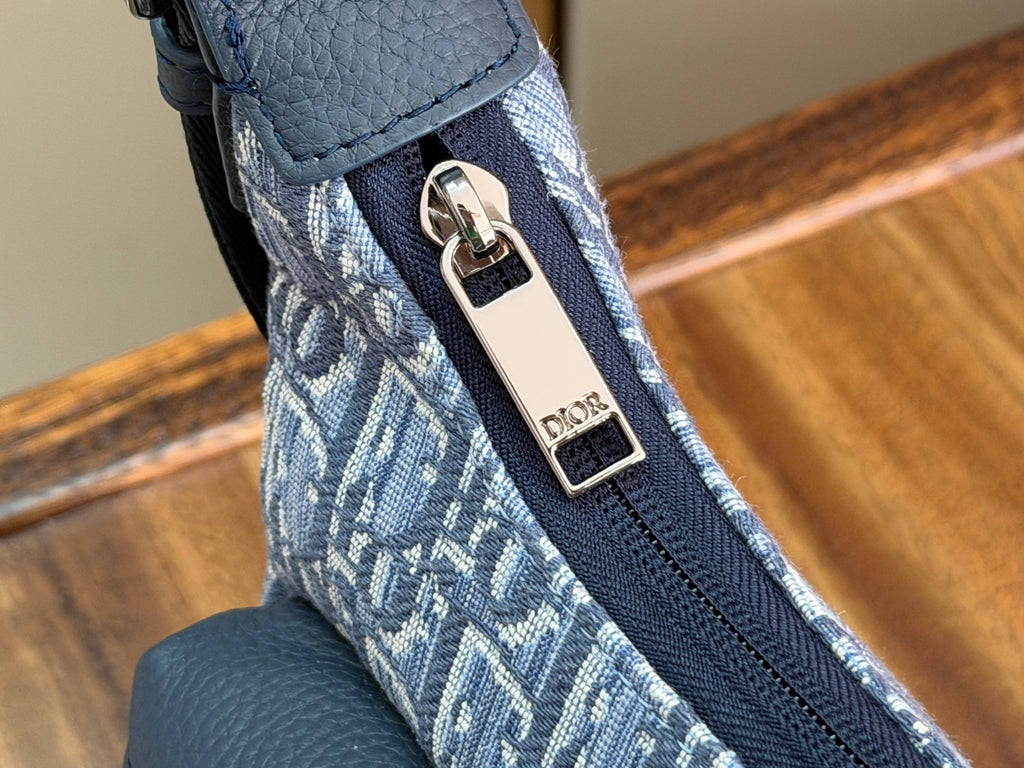 Metal buckle and Dior-branded tag on blue Oblique shoulder strap