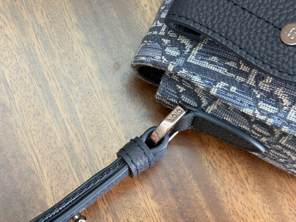 Blue monogram crossbody bag close-up of strap attachment and metal ring