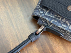 Blue monogram crossbody bag close-up of strap attachment and metal ring