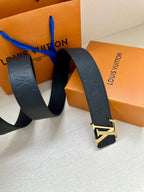 Navy Louis Vuitton belt with embossed strap and silver-tone LV buckle, angled.