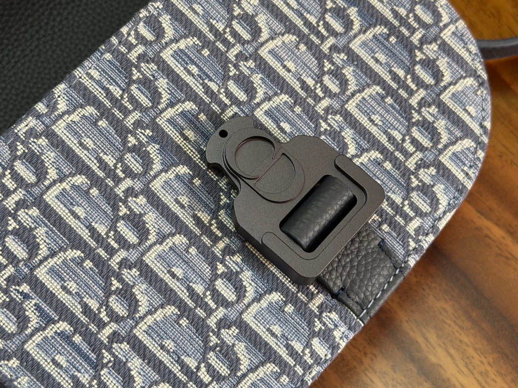 Dior-pattern crossbody bag clasp close-up on blue leather and textured fabric