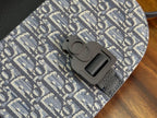 Dior-pattern crossbody bag clasp close-up on blue leather and textured fabric