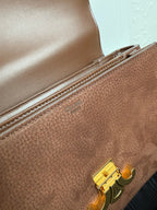 Celine bag interior pocket with gold clasp hardware on textured brown leather