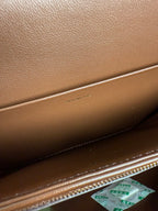 Celine bag interior with paper notes and gold zipper trim in textured brown leather