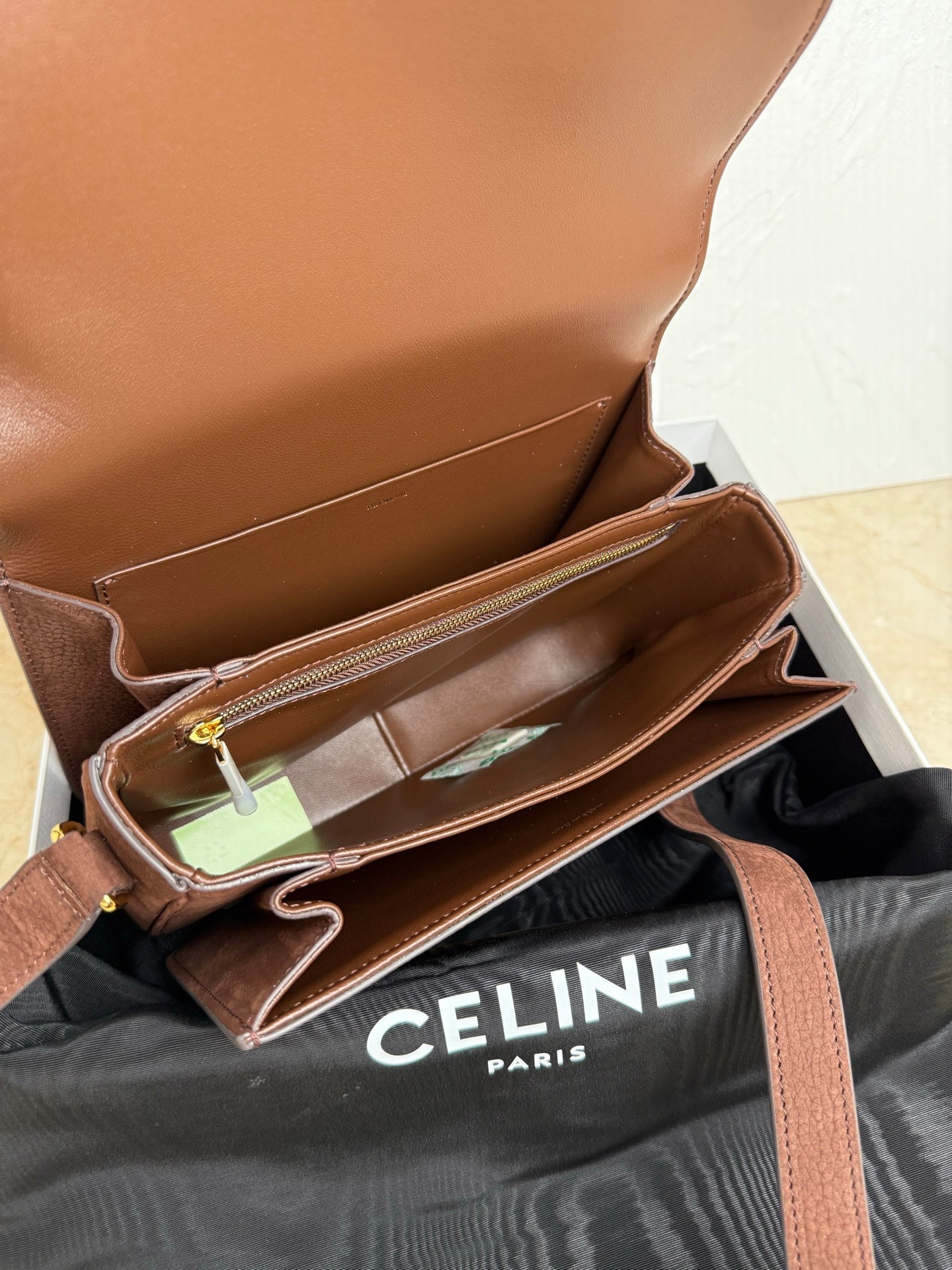 Celine bag interior open with card slots and gold zipper pull on brown leather