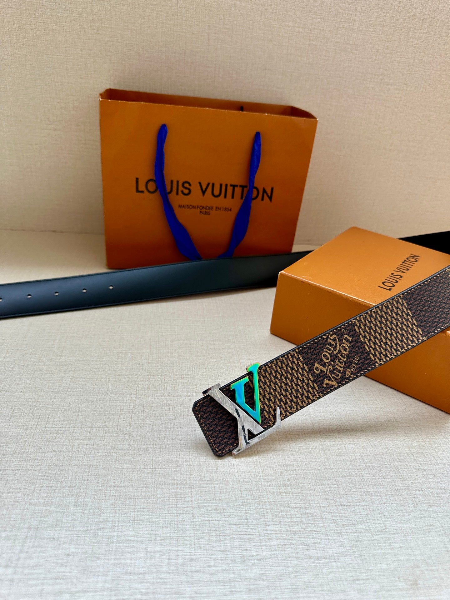 Louis Vuitton dark monogram belt with silver LV buckle and teal-green inlay