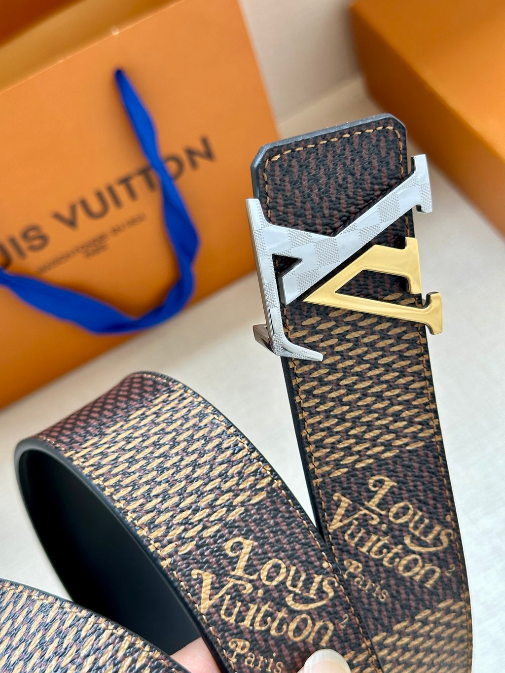 Louis Vuitton monogram belt with dark strap and silver-tone LV buckle with gold accent