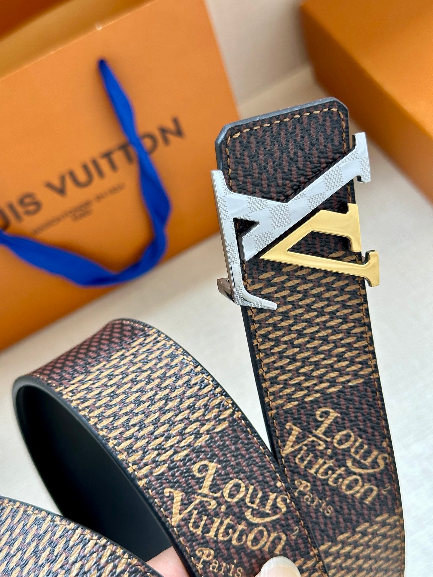 Louis Vuitton monogram belt with dark strap and silver-tone LV buckle with gold accent