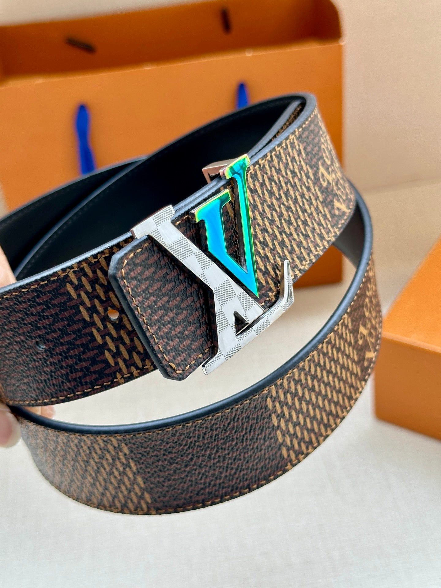 Louis Vuitton monogram belt with silver LV buckle and teal-green detail on clasp