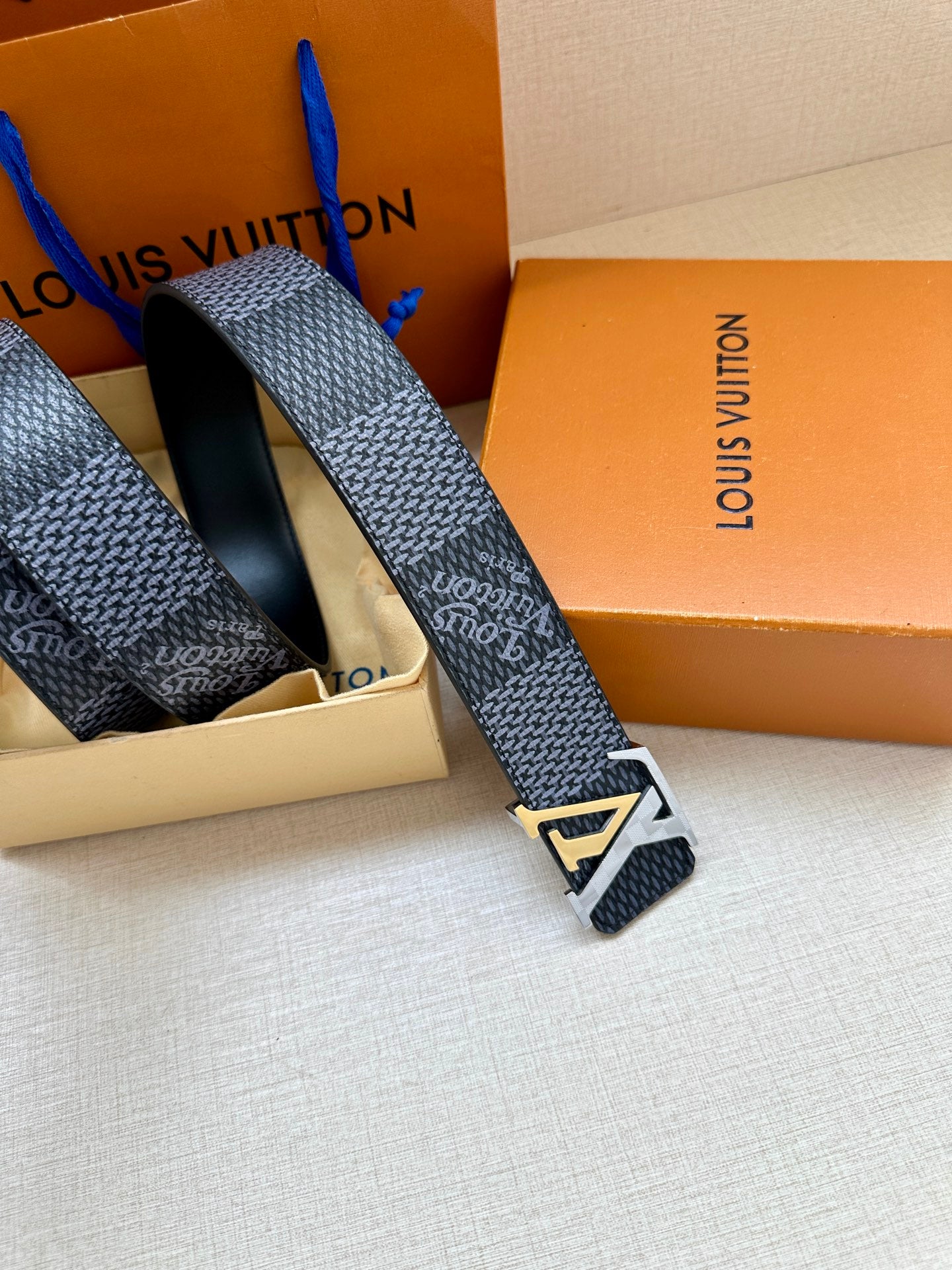 Dark blue embossed belt end with silver buckle and textured strap
