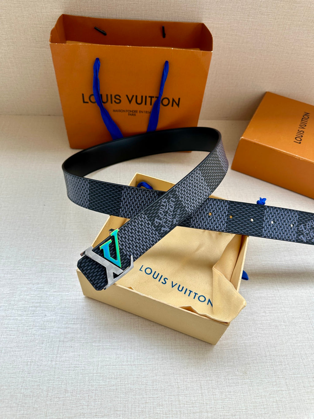Dark blue embossed belt with large silver buckle and cutout details