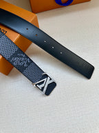 Two dark blue belt straps with silver buckle hardware and punched holes