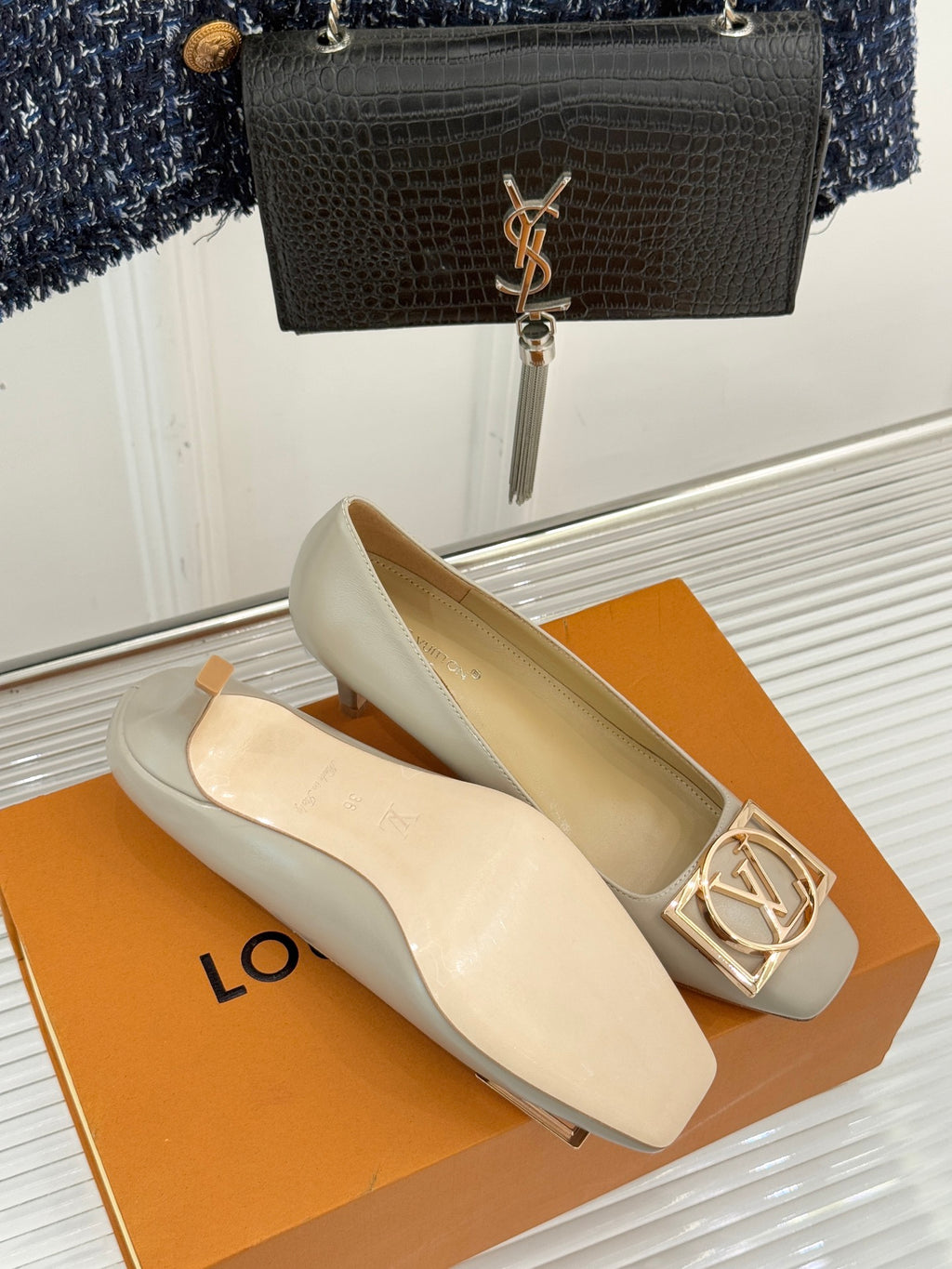 Cream Louis Vuitton pumps with gold square logo buckle and low heel
