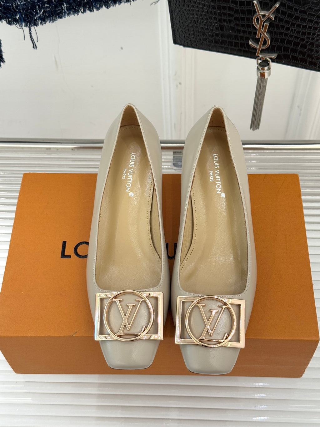Cream Louis Vuitton pumps with gold logo hardware at the toe