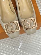 Cream Louis Vuitton pumps with gold LV monogram buckle detail