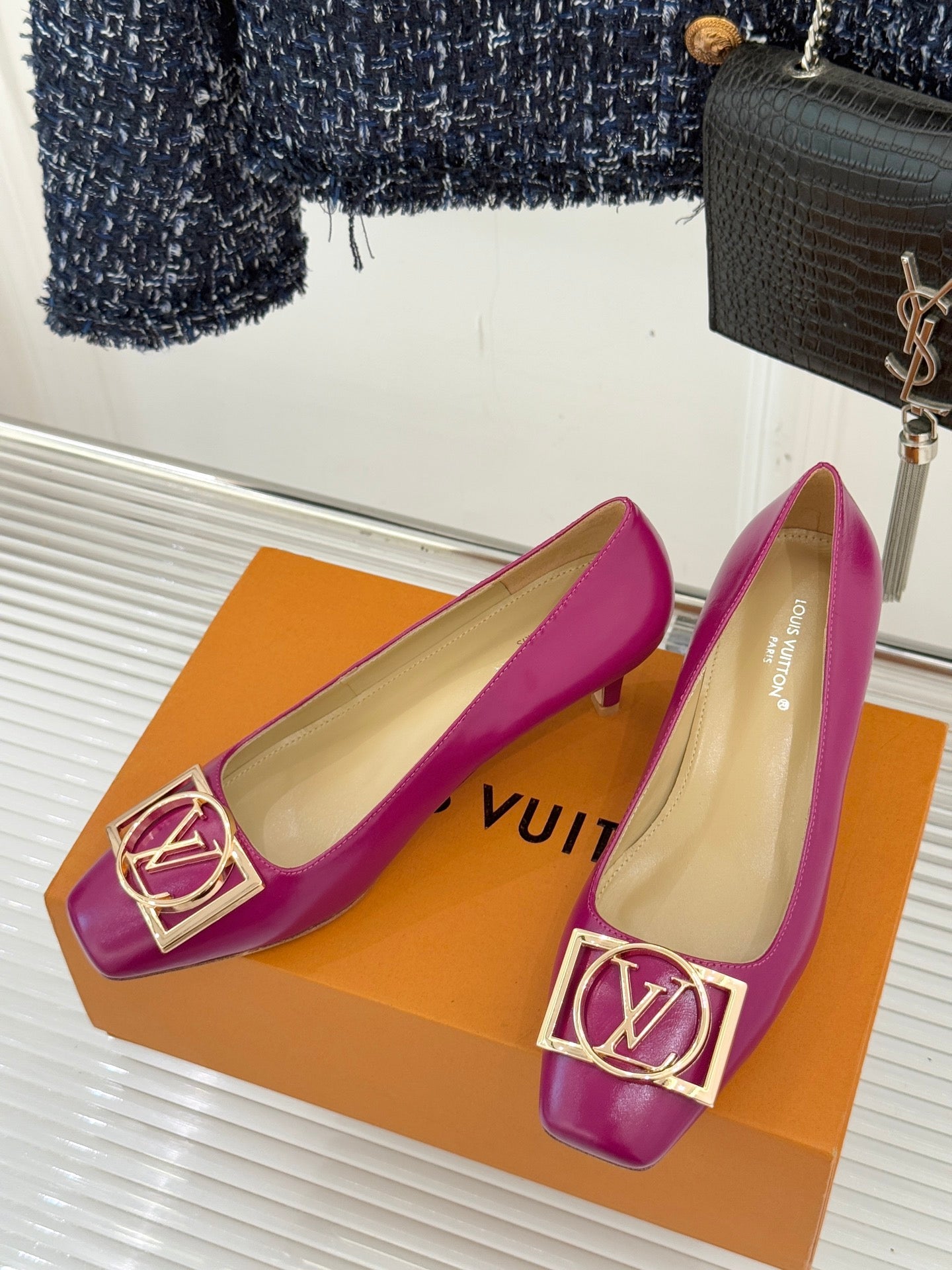 Pair of pink Louis Vuitton slingback-style heels with gold LV logo buckle detail