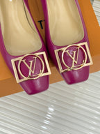 Close-up of pink Louis Vuitton heels with gold LV logo buckle trim at the toe