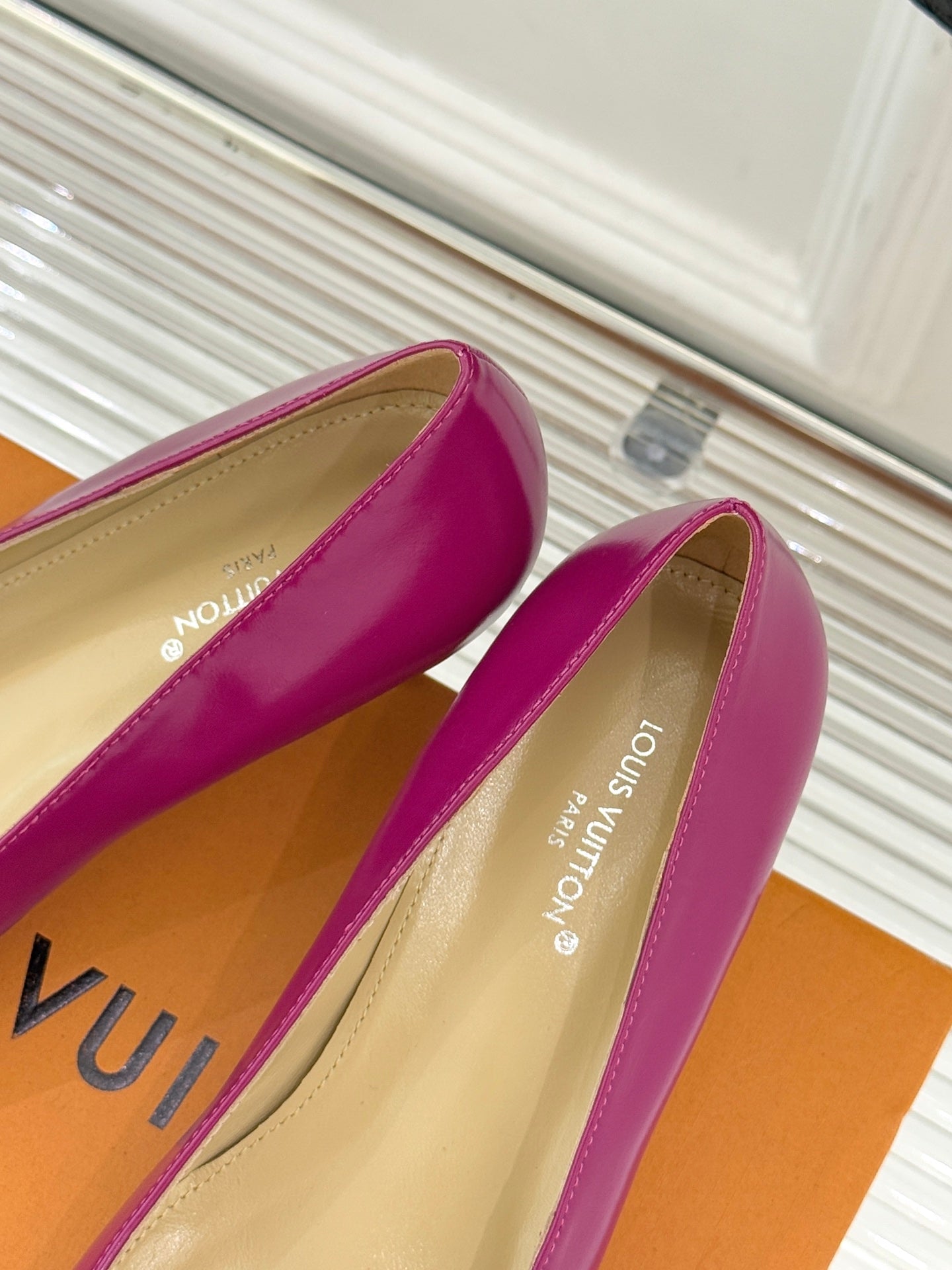 Pink Louis Vuitton ladies’ heels, cream lining visible, with gold LV logo detail