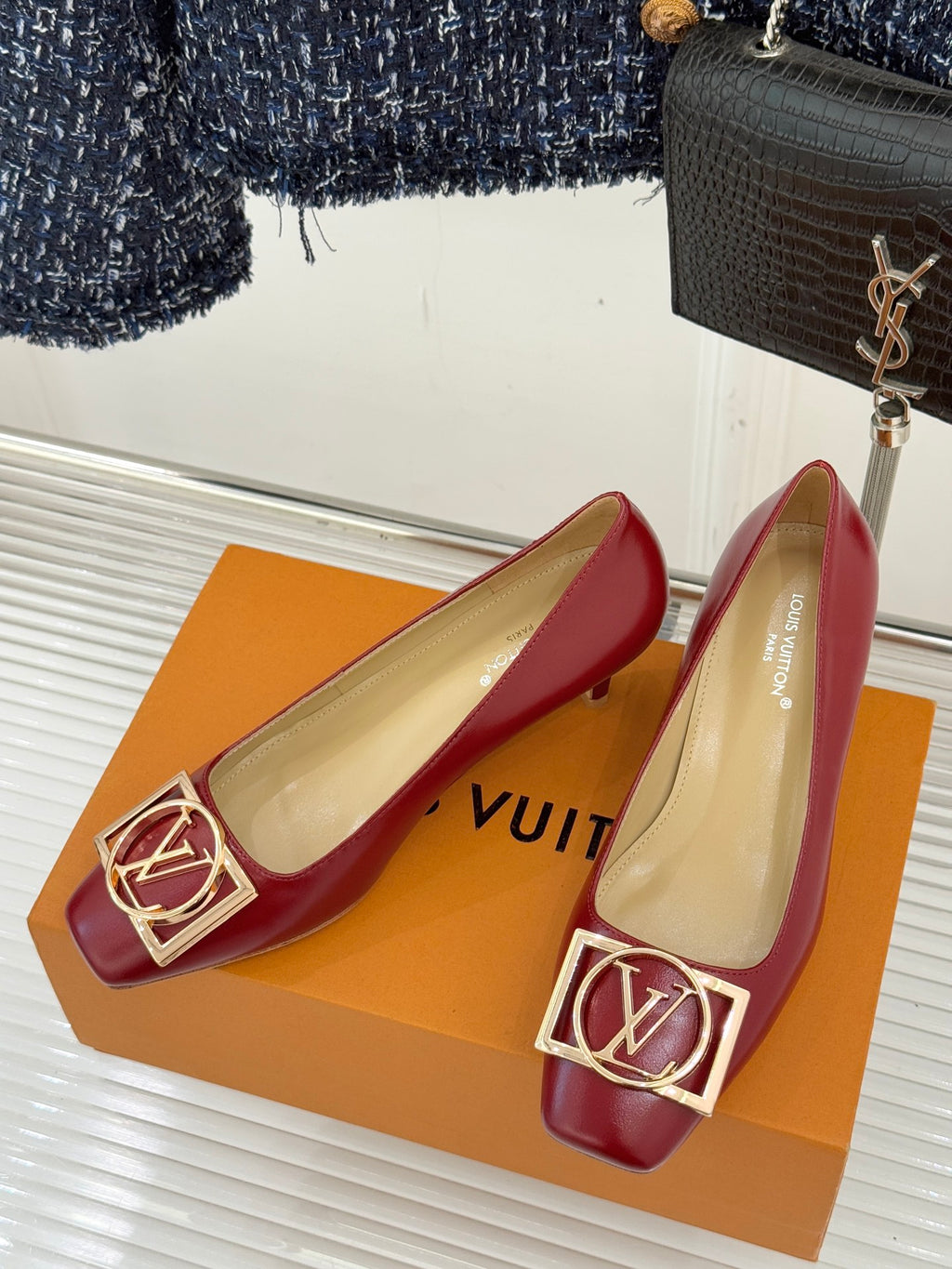Louis Vuitton ladies red pointed-toe pumps with gold LV buckle on front, beige lining