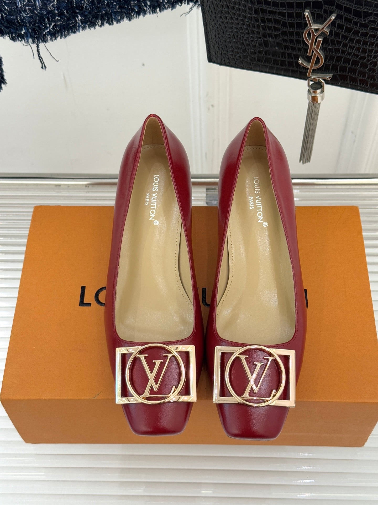 Louis Vuitton ladies red low-heel pumps, front view with gold LV buckle, beige interior