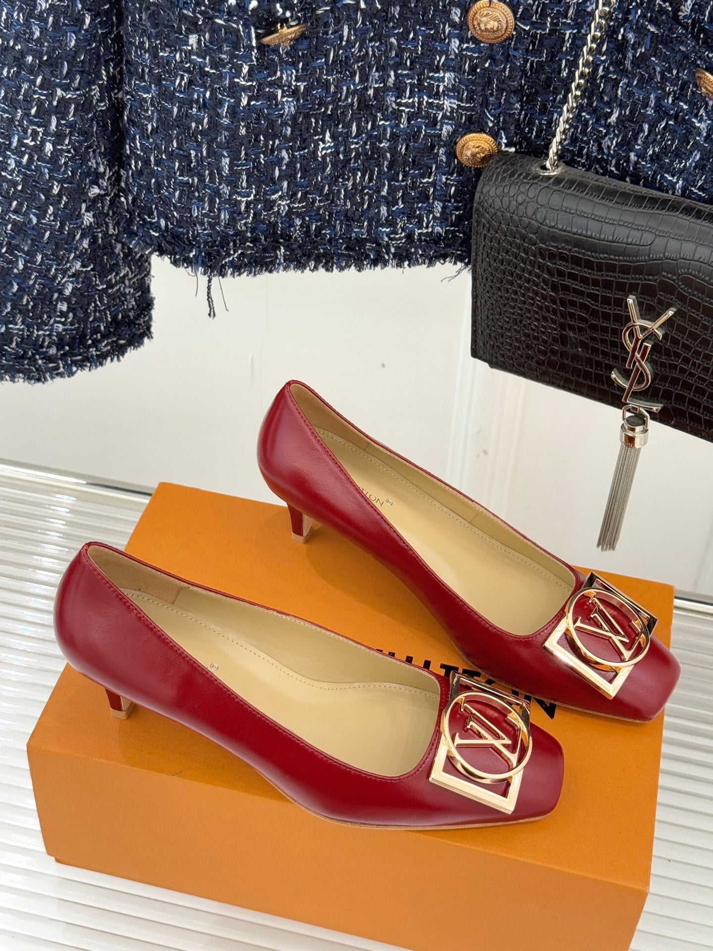 Louis Vuitton ladies red low-heel pumps with gold LV buckle, pair on orange box