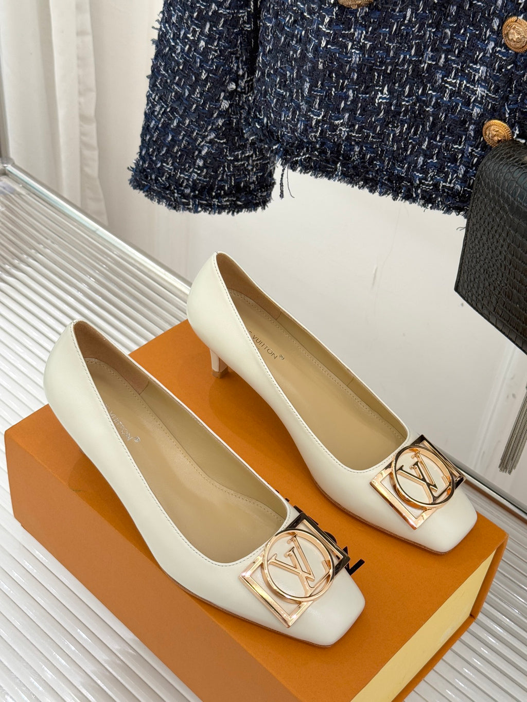 Louis Vuitton ladies’ light leather flats with square toe and gold-tone LV buckle detail