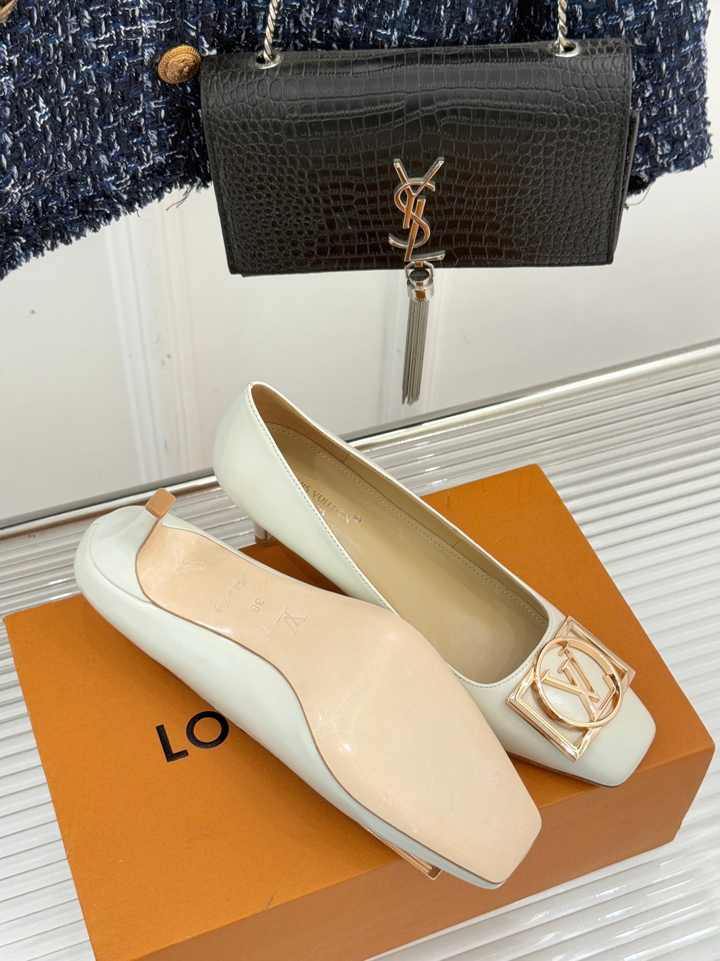 Louis Vuitton ladies’ light flats with gold-tone LV buckle and low block heel, shown in pair