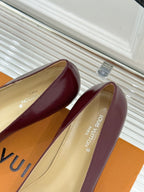 Burgundy low-heel pumps with cream lining and printed insole text.
