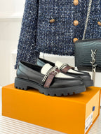 Black leather loafer with white upper panel, chain detail, and chunky tread sole
