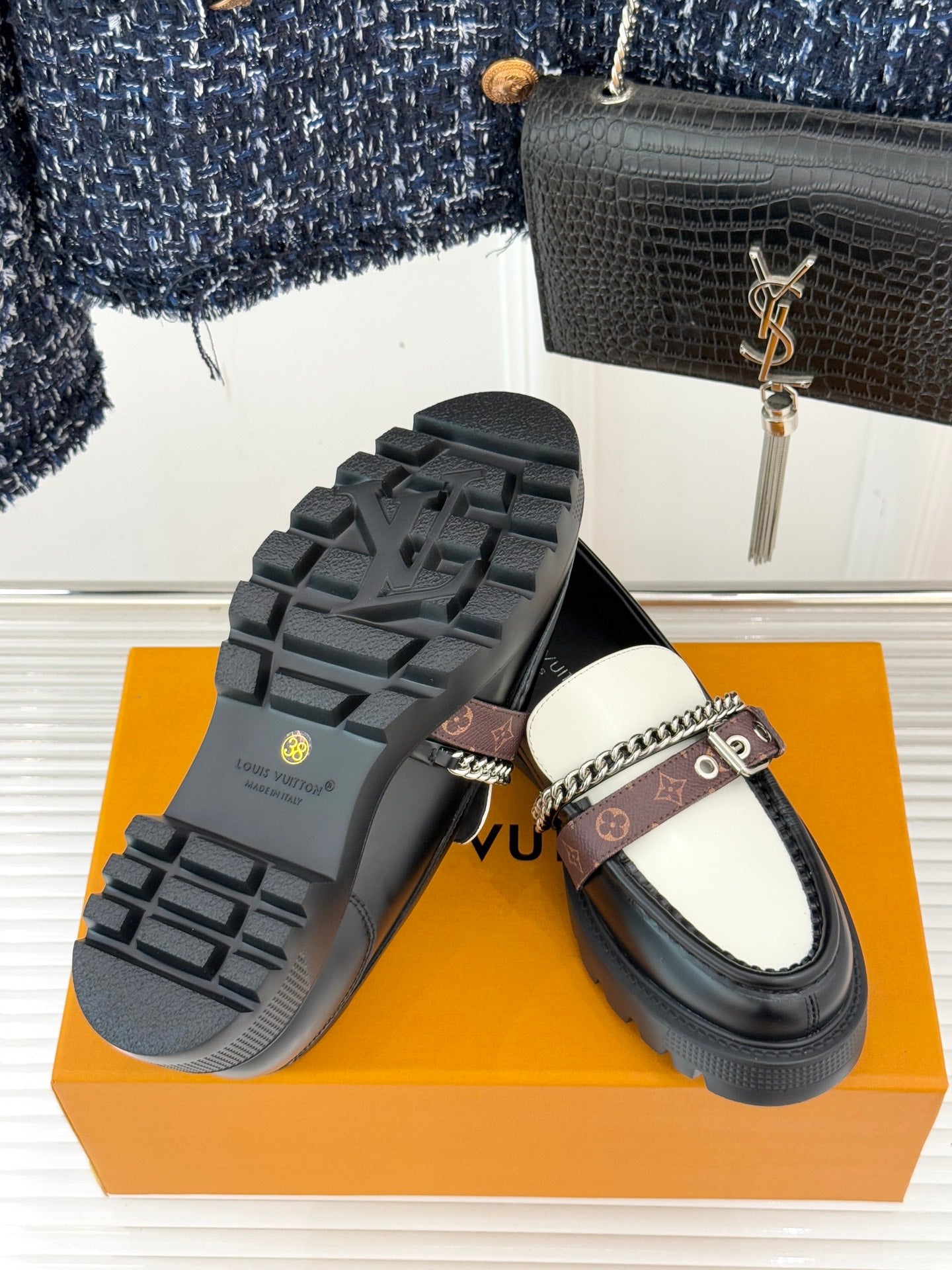 Loafer underside view showing chunky tread sole and monogram chain strap upper