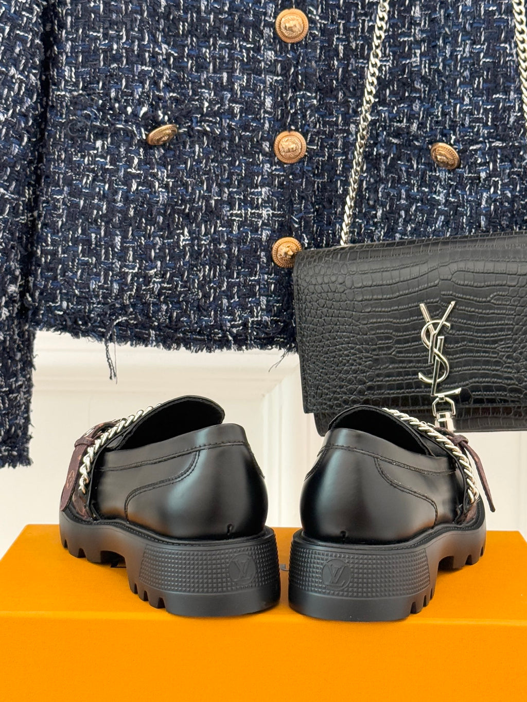 Back view of black leather loafers with chain straps and chunky tread sole