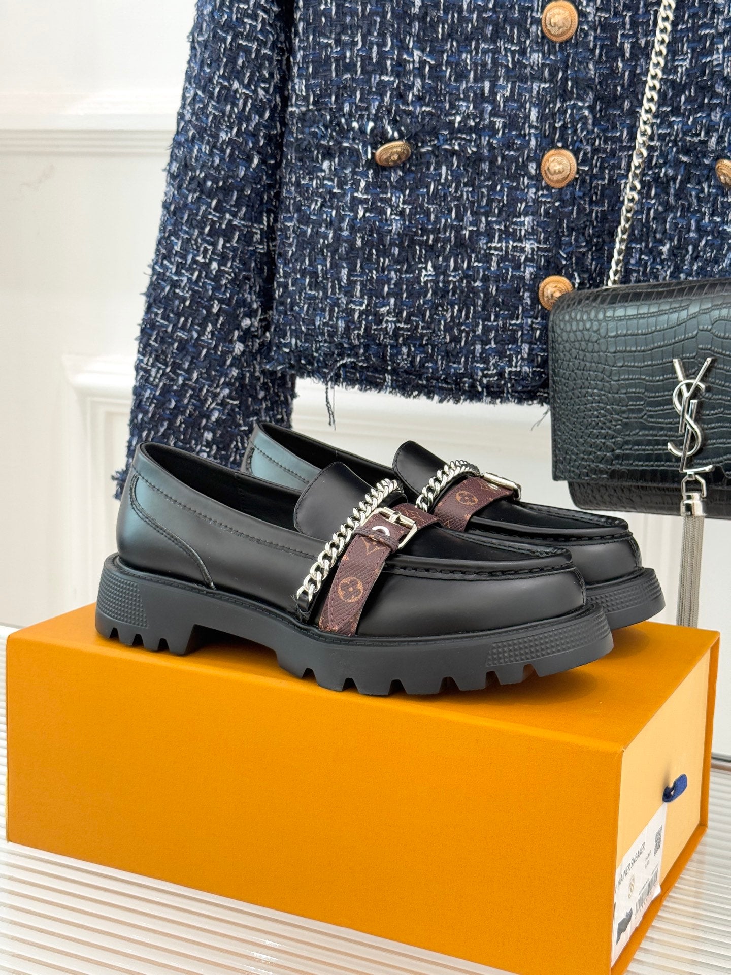 Black leather loafers with chain trim, monogram strap, and chunky platform sole