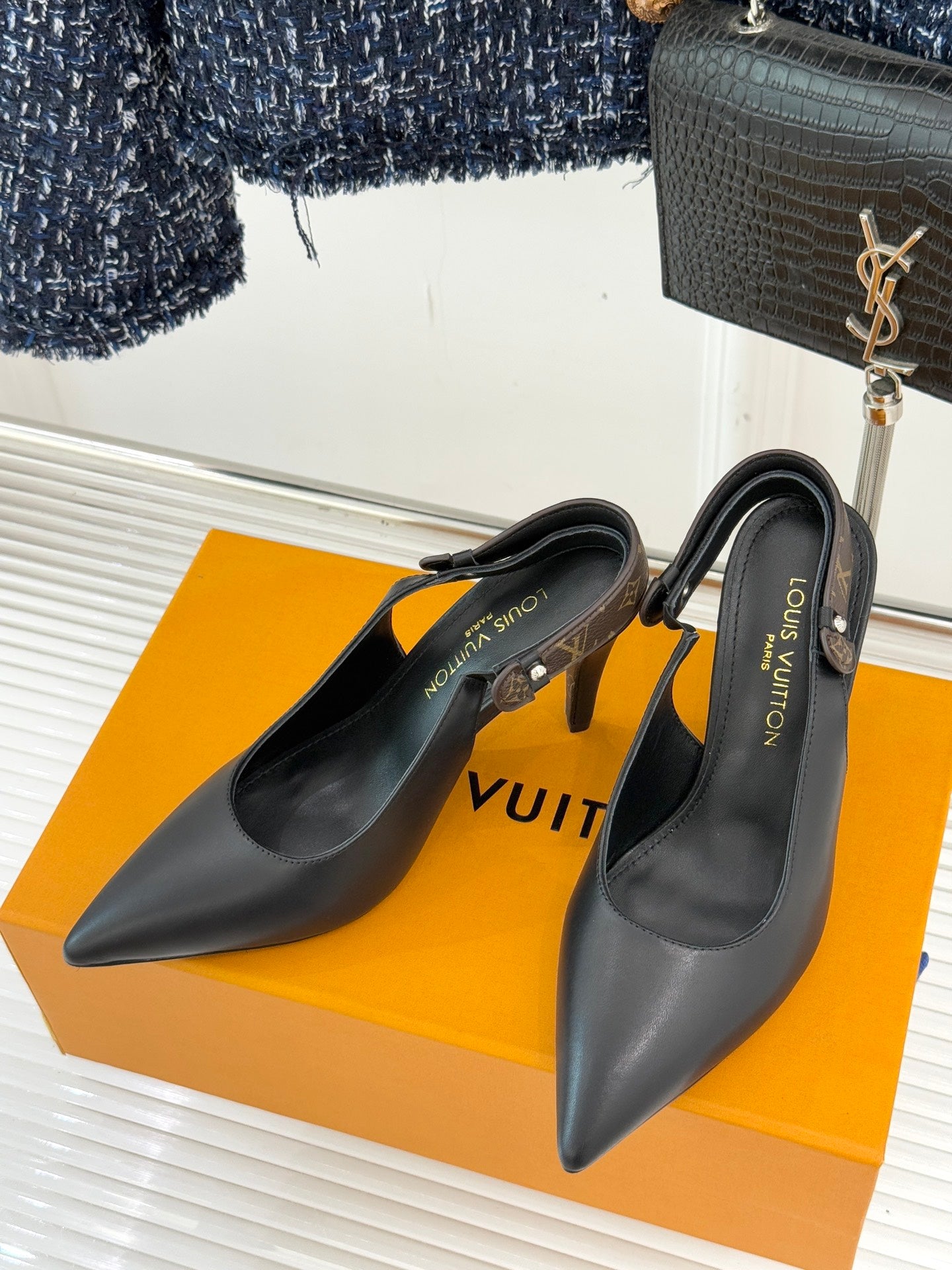 Louis Vuitton black pointed-toe heeled pumps set on display