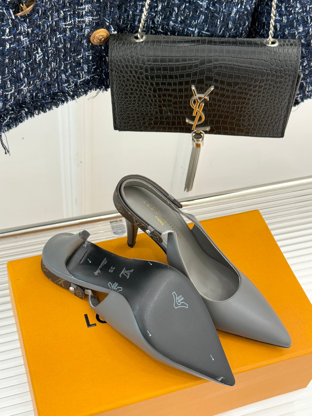 Light gray pointed-toe heeled slingback pumps with slim stiletto heel