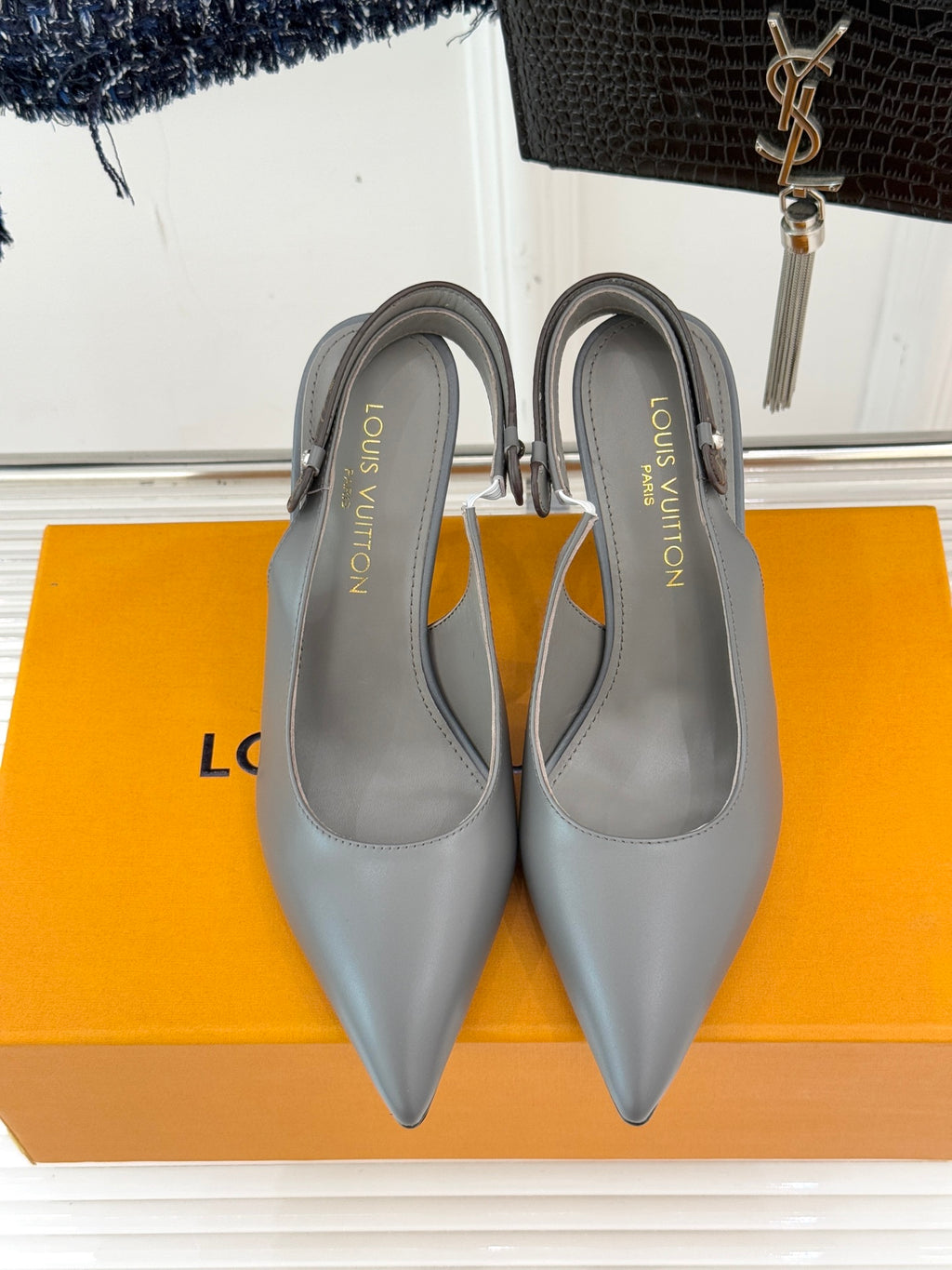 Light gray slingback pumps with pointed toes and slim stiletto heels