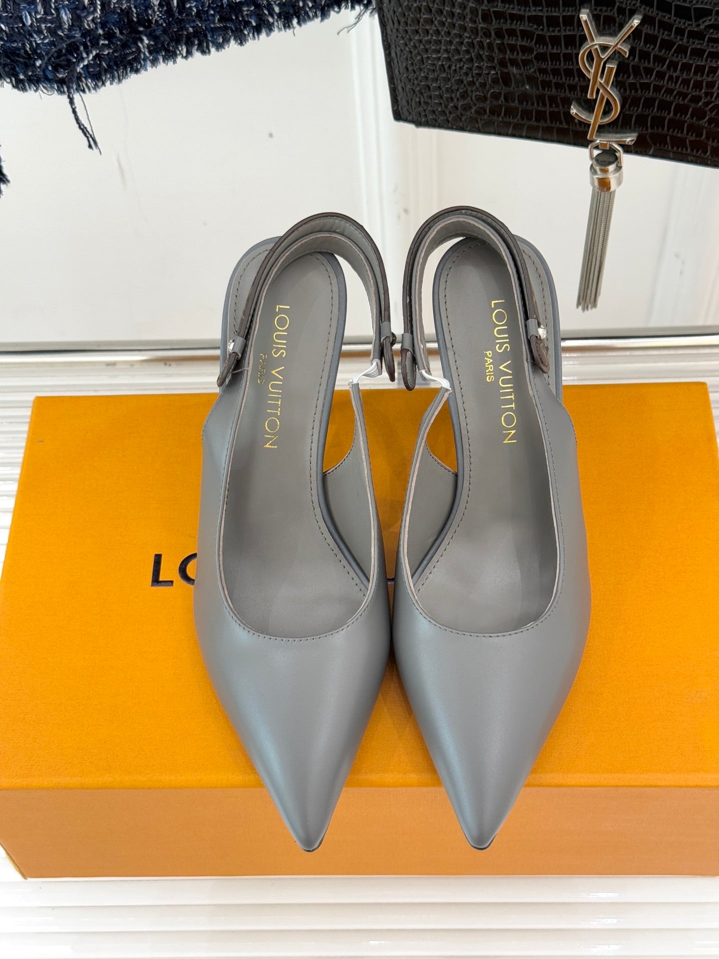 Light gray slingback pumps with pointed toes and slim stiletto heels