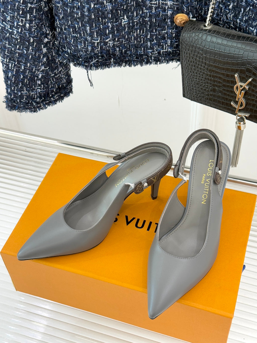 Light gray slingback pumps with pointed toe and slim stiletto heel on display