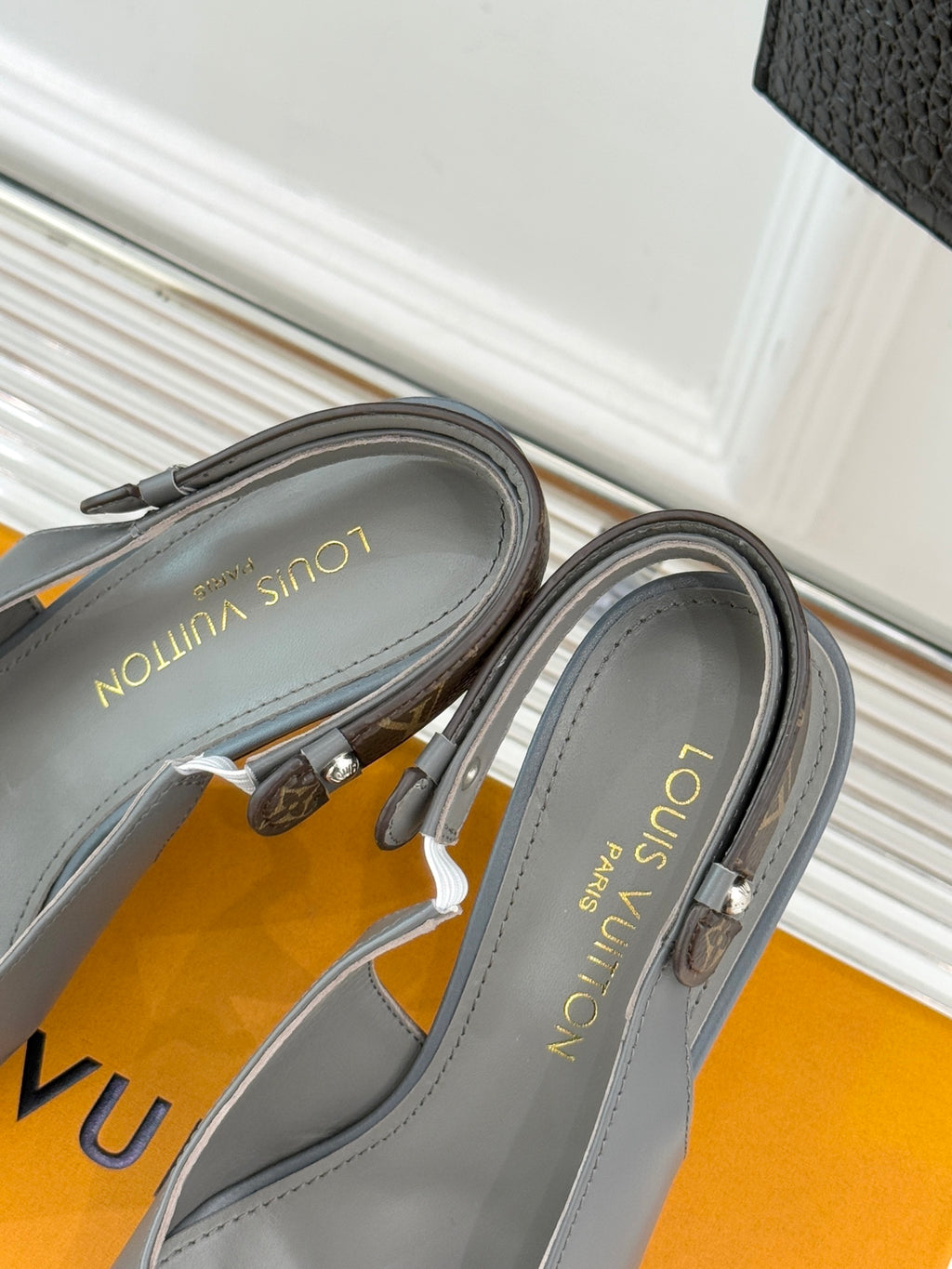 Close-up of light gray slingback pumps showing inner lining and stitching